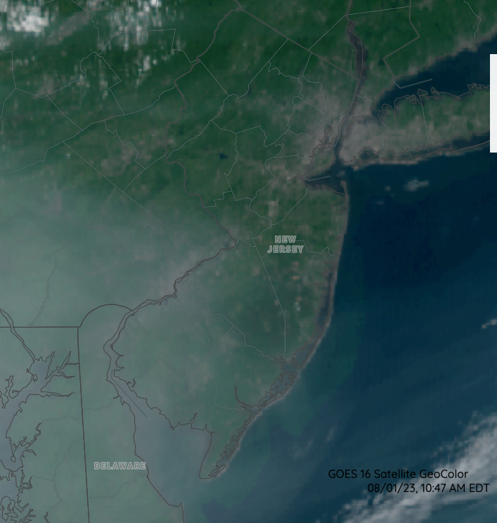 Visible satellite image at 10:47 AM on August 1st showing the high-altitude smoke veil over southern NJ and adjacent southeast PA, northeast MD, and north DE, Delaware Bay, and in the adjacent Atlantic (NOAA GOES image).