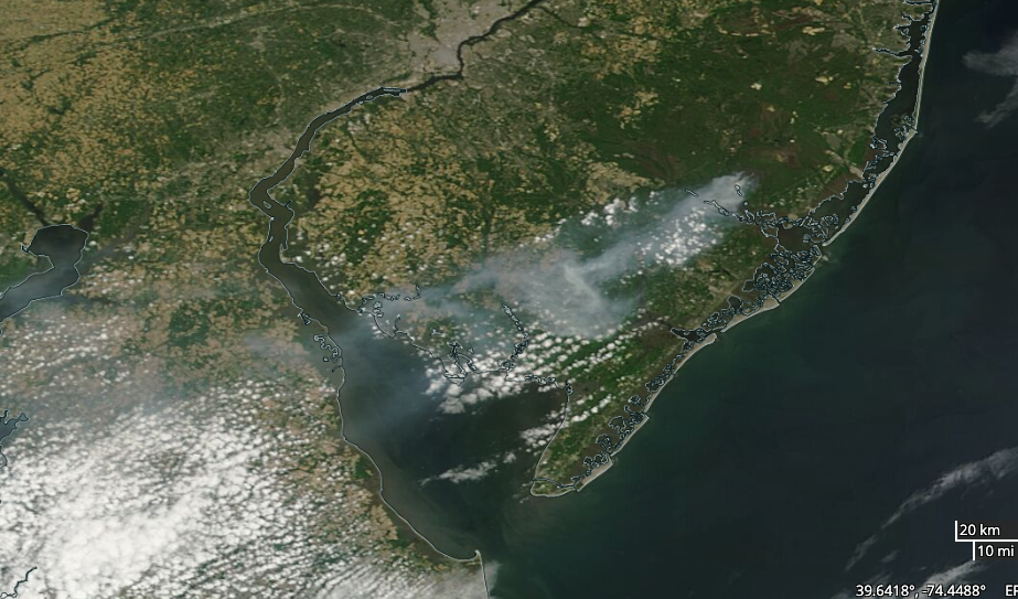 Figure 2. MODIS Terra visible satellite image at approximately 10 AM on June 1 showing grey smoke from the Bass River fire drifting southwestward over south Jersey, Delaware Bay, and central Delaware. The brighter features are cumulus clouds. Courtesy of NASA. MODIS Terra visible satellite image at approximately 10 AM on June 1 showing grey smoke from the Bass River fire drifting southwestward over south Jersey, Delaware Bay, and central Delaware.