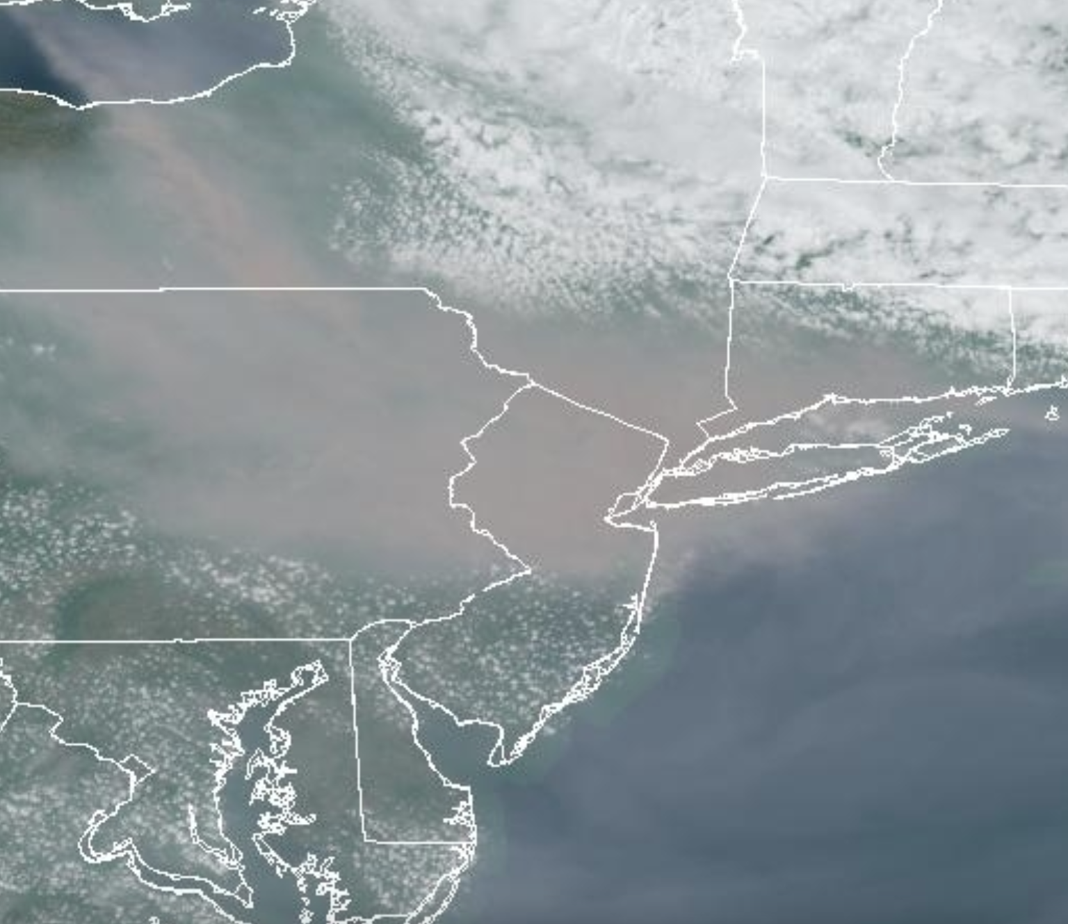 Figure 3. Smoky skies over northern New Jersey and surroundings at 2:02 PM on June 7th. Note the presence of scattered cumulus clouds south of the area of densest smoke where the atmosphere is less stable than within the smoky zone. (NOAA GOES visible satellite image). Smoky skies over northern New Jersey and surroundings at 2:02 PM on June 7th, as seen by NOAA GOES visible satellite.